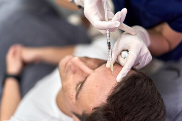 Man receiving a vaccine with collagen to perform a facial beauty treatment