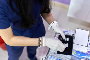Doctor picking up two bottles of solution from a box for a facial treatment
