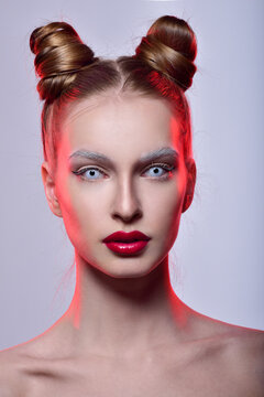 Halloween makeup. White lenses in the eyes. Horns on her head. Professional Makeup and hairstyle. Red Lipstick.