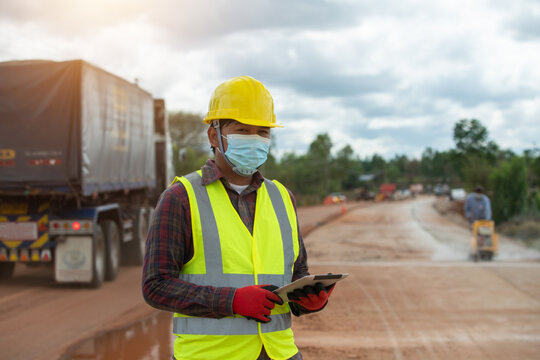 Foreman worker in uniform holding a tablet working in the road construction