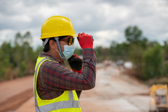 Foreman worker in uniform wearing helmet in road construction site