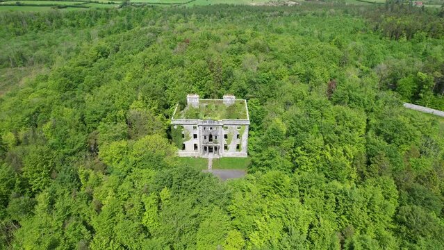 A big ruin house covered ivy and surrounded by a forest , Moore Hall is located in county Mayo Ireland and is now a public area