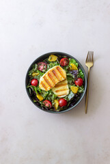 Salad with grilled halloumi cheese, tomatoes, orange and pumpkin seeds. Healthy eating. Vegetarian food. Keto diet.