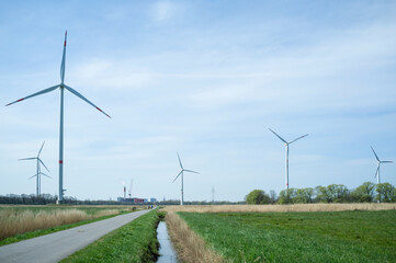 Wind turbines in the fields in the countryside, next to the road. Clean energy concept.