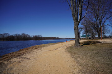 Dirt walking path along a lake during early spring.