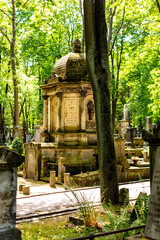Zabytkowy cmentarz w centrum miasta w Warszawie. Zielone drzewa, pomniki, krzyże i rzeźby. Stare...