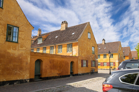 Beautiful view of old yellow houses in famous Nyboder districk with a bikes. High quality photo
