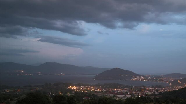 Evening time lapse. The passing of thunderstorm, storm, rain  over lake Orestiada near the city of Kastoria. Sunset with a thunder, lightning over a mountain peak in Greece