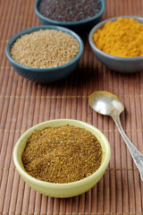 Powder spice blend from black and white mustard seeds and turmeric. Indian mustard powder seasoning in bowl.