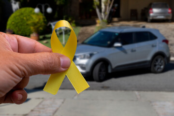 yellow may. hand holding yellow ribbon. traffic accident prevention campaign