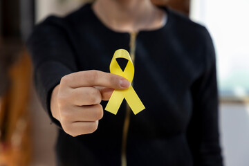 woman holding yellow ribbon. traffic accident prevention campaign or campaign against suicide. - obrazy, fototapety, plakaty