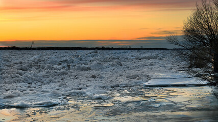 Spring ice drift on the river at sunset.