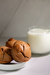 Homemade  cupcakes with a glass of milk on a light background