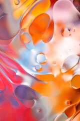 Close-up of the movement of oil droplets on the water surface. Colorful abstract macro background of oil drops on the water surface. © fusssergei