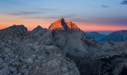 Mount Jalovec at sunrise glows in vivid colors