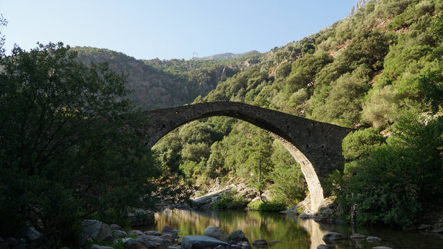 Old genovese stone bridge over the River Porto near Ota Village on Corsica Island in France.