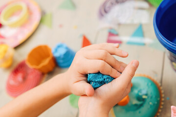 kinetic sand. children's hands play with multi-colored polymer sand.