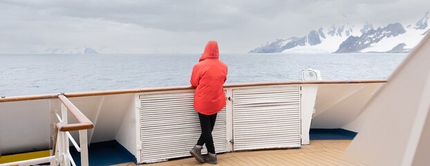 Passagiere auf einer Antarktisexpedition am Bug eines Schiffes 