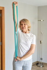 mature woman doing sports at home with a rubber band