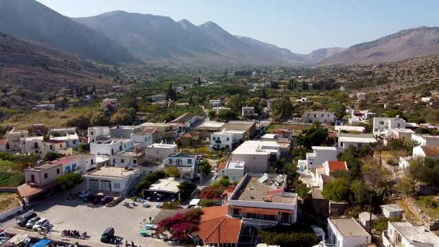 Backward reveal aerial shot of Vathys village on sunny day. Kalymnos island, Greece.