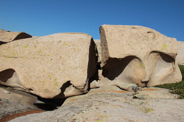 A large white volcanic stone split into two pieces lies on a stone slab in the Bektau Ata tract, clear sky, sunny, summer