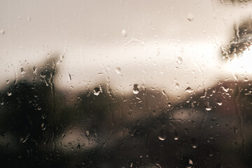 Raindrops on window against rainy British town backdrop