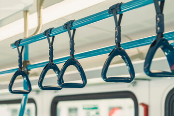 Close-up of plastic handles for standing passengers safety in public transportation, selective focus