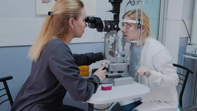 ophthalmologist examining the eyesight of woman with a slit lamp