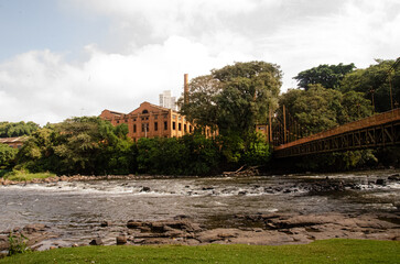 Fototapeta na wymiar Construction of the central mill, and view of the wooden bridge, in the city of Piracicaba.
