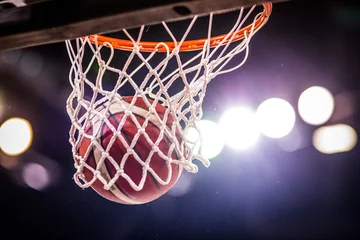 Fotobehang basketball game ball going through hoop © Melinda Nagy