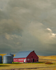 Fototapeta na wymiar A red barn with a stormy sky in the fall season in the palouse wheat country in southeastern Washington.