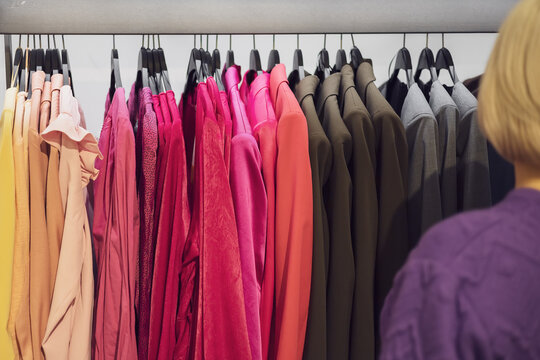 Women's clothes hang in a row on a hanger. Choose an outfit in a fashion store