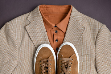 Men brown suede sneakers combined with light beige blazer and T-shirt. Casual summer outlook. Top view.