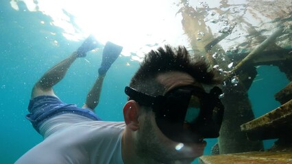 snorkeling and Swimming. diving a man, in a snorkeling mask, is exploring underwater coral reef with countless colorful and fish