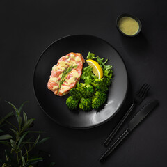 Steamed salmon steak with sauce, broccoli and lemon