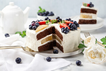 chocolate cake decorated with fresh berries on a light background. Sweets concept.