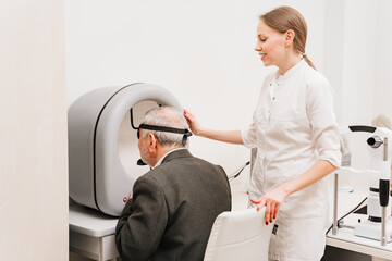 oculist examination of elderly man on device perimeter of field of view