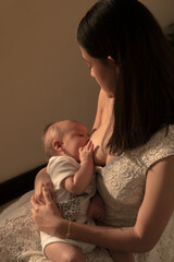 Latin mother lactating newborn baby, breastfeeding on the sun set