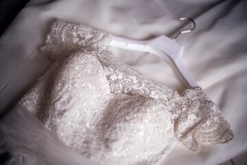 Detalle de la parte frontal de un vestido de novia blanco con encaje.