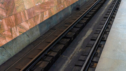 Fototapeta na wymiar Subway station view on rails. Railroad track in metro. The most convenient urban public transport.