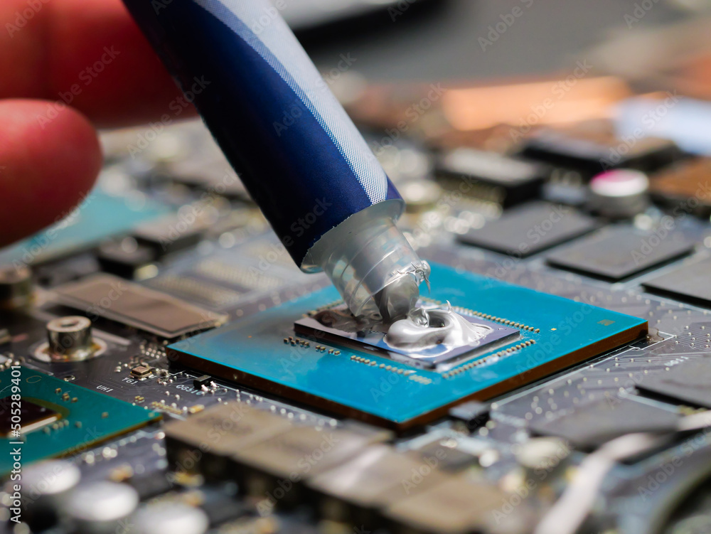 Poster the close up image of technician squeezing the fresh thermal paste compound on the top of gpu in the