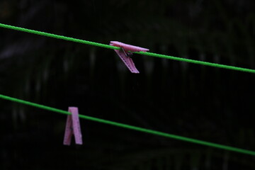 group of color wet plastic clip hang on the rope after rain without clothes