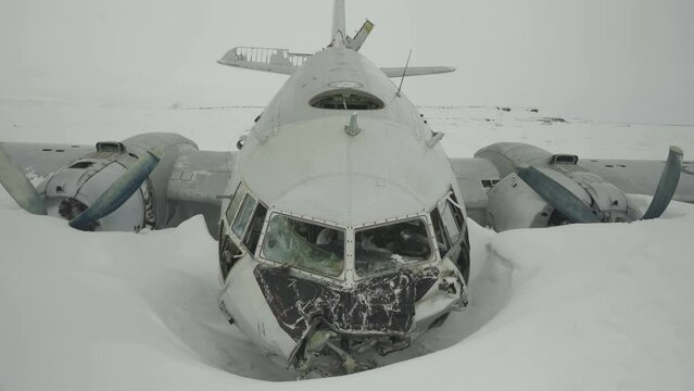 Crashed plane on snow. Aircraft fuselage. Broken nose andaircraft tail, stabilizer. Front view. Turboprop airplane