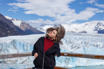 Girl with flowing hair against the backdrop of the Perito Moreno glacier and Lake Argentina