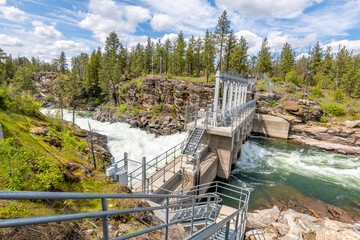 The dam at Falls Park along the Spokane River with roaring rapids in the rural town of Post Falls,...