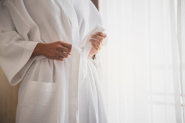 Fototapeta na wymiar Joyous attractive girl in white bathrobe after spa. Young healthy serene woman girl relaxing after having bath shower at home. Beauty treatment, rest and body care procedures.
