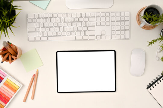 Minimal white office desk workspace top view with empty screen tablet touchpad