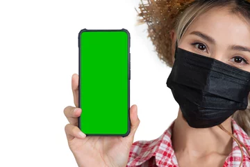 Fotobehang Closed-up female tourist face holding smartphone shown green sereen on white background. © pandpstock001