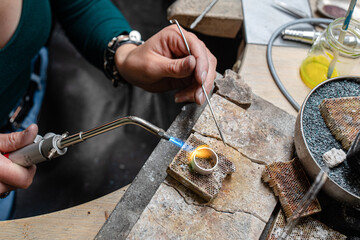 A ring mold is heated with a forging tool by a goldsmith