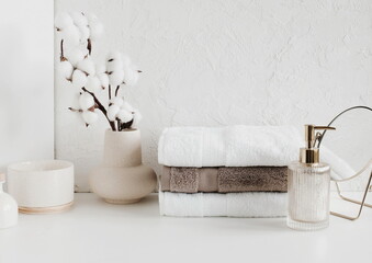 Spa, bathroom background. Towels on white desk near white wall and interior accessories with copy...